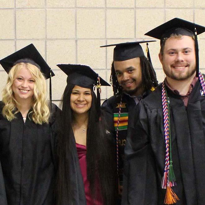 Four TRIO students in their graduation attire.