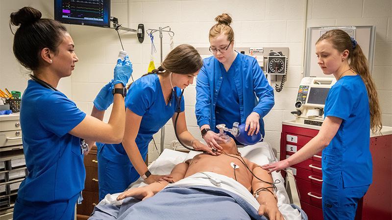 Nursing Students standing around medical human dummy